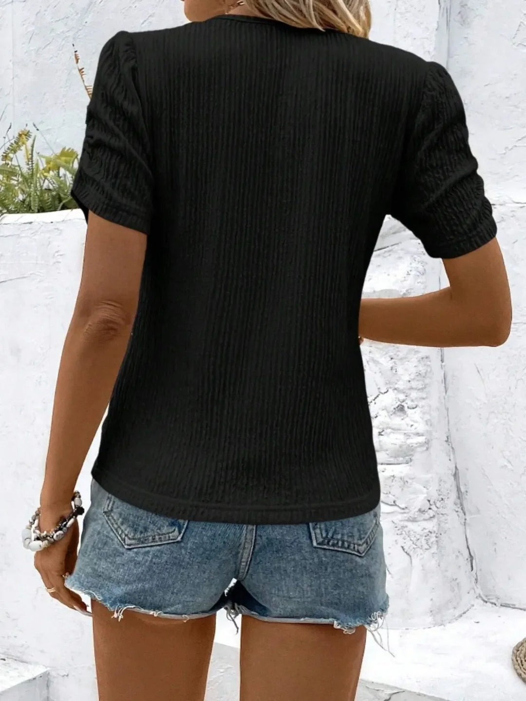 Comfortable women's ruched short sleeve top, showcasing its soft knit fabric and flattering fitted cut.