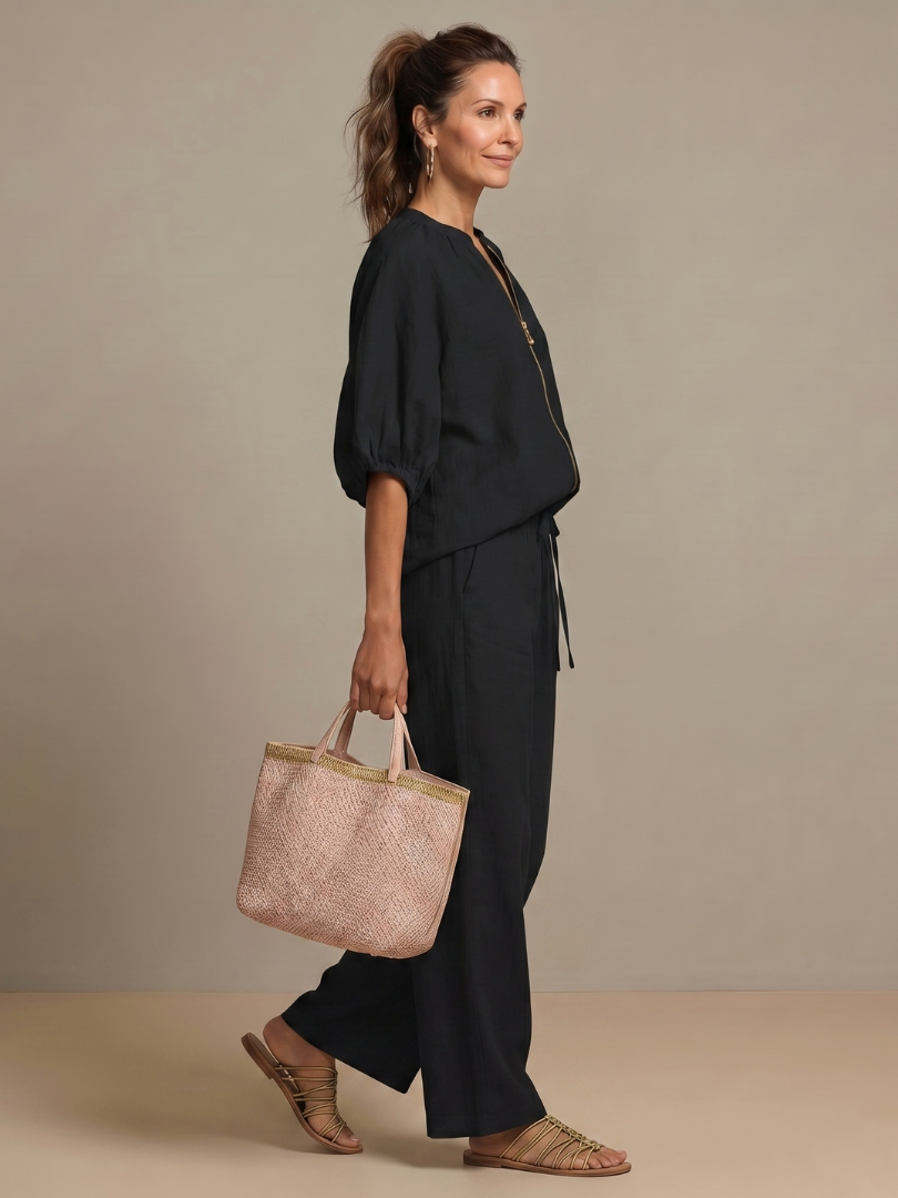 A woman poses confidently in the elegant women's co-ord set: wide leg pants & zip-front top.
