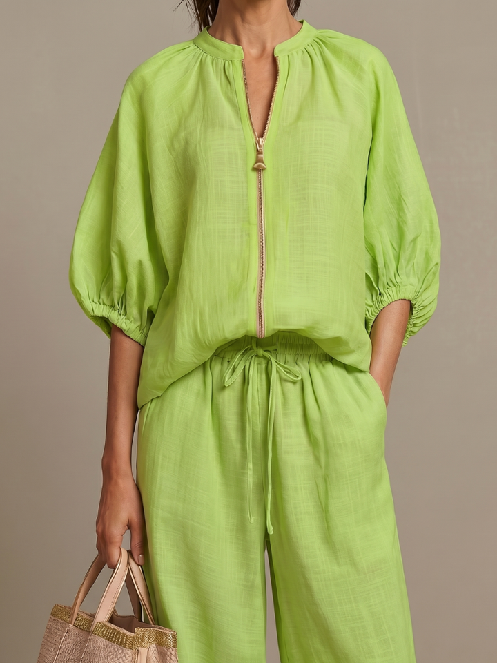 Full view of a model wearing a women's co-ord set: wide leg pants & zip-front top.