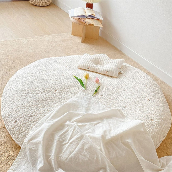 Washable, soft cotton infant playmat with padded animal design for safe crawling.