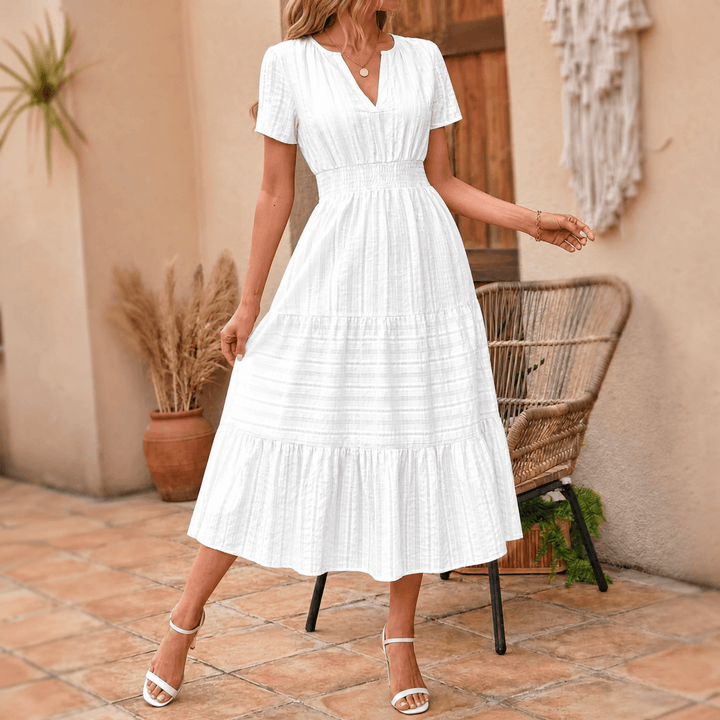 Light and breezy tiered midi dress with short sleeves, V-neck, smocked waist, and essential pockets.
