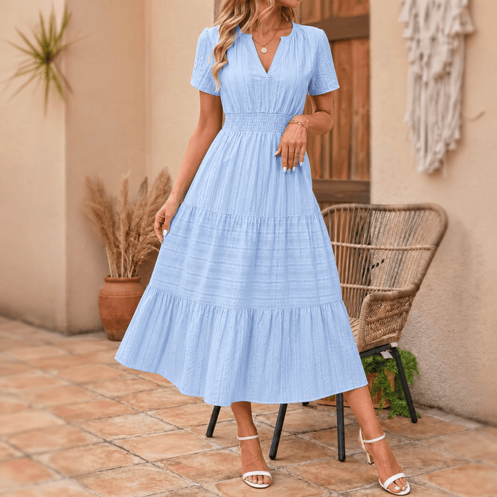 Achieve casual elegance with this tiered midi dress: V-neck, smocked waist, short sleeves, and pockets.