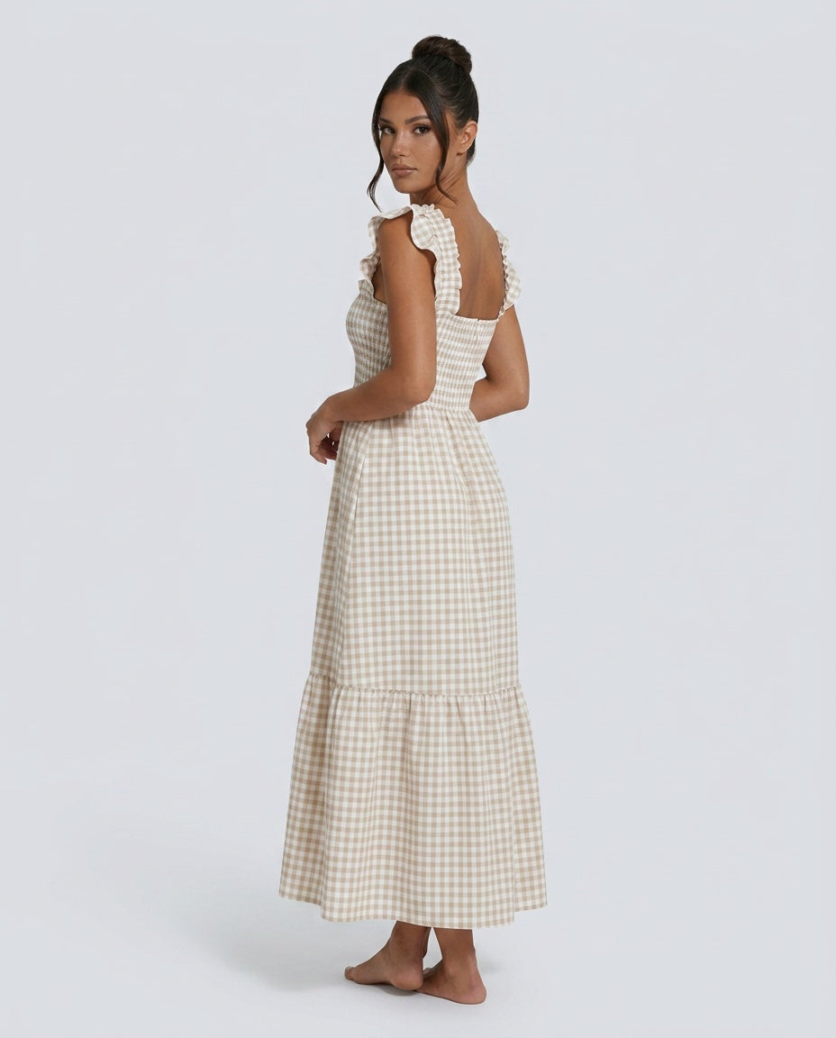 Flowy women's gingham maxi dress featuring smocked bodice, tiered skirt, and stylish ruffle sleeves.
