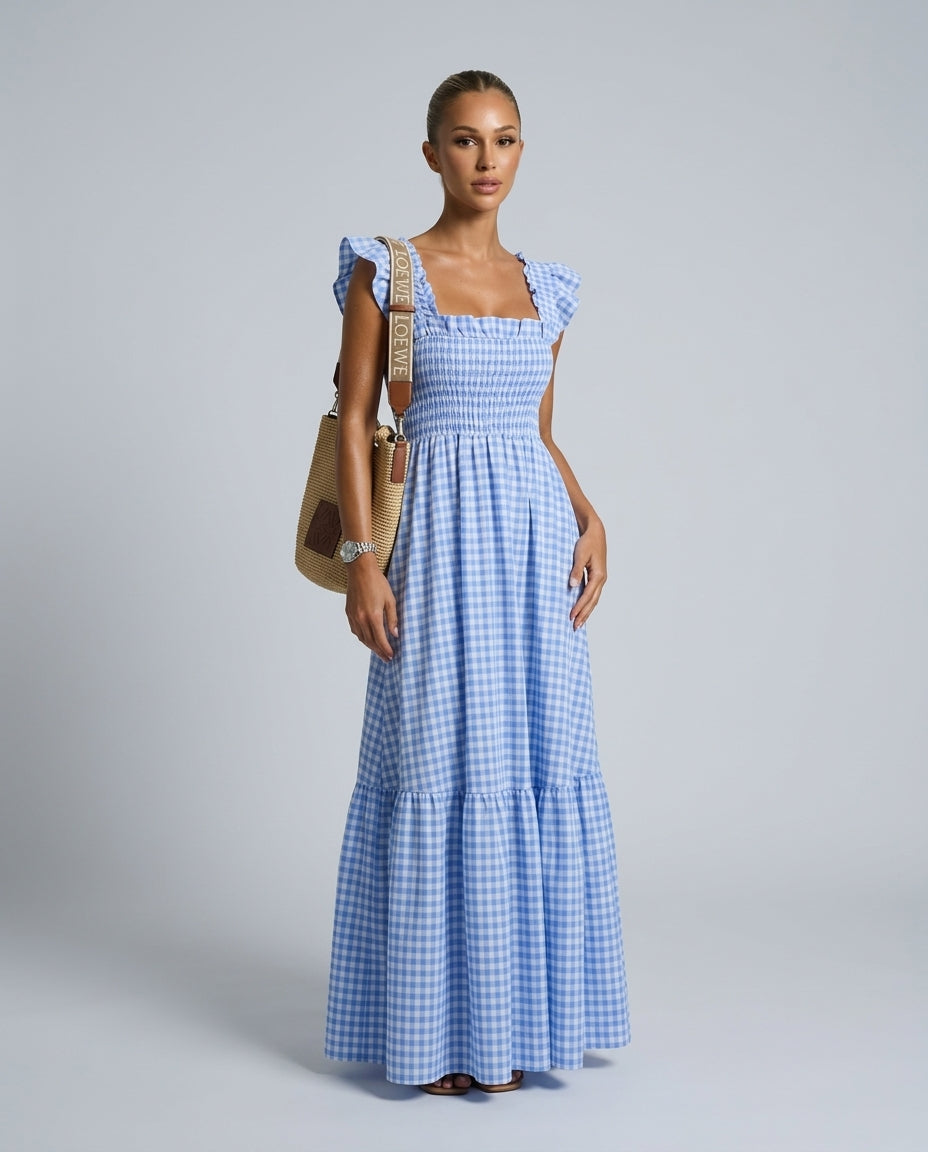 Chic women's gingham maxi dress with smocked top, tiered skirt, and romantic ruffle sleeves, flowy fit.