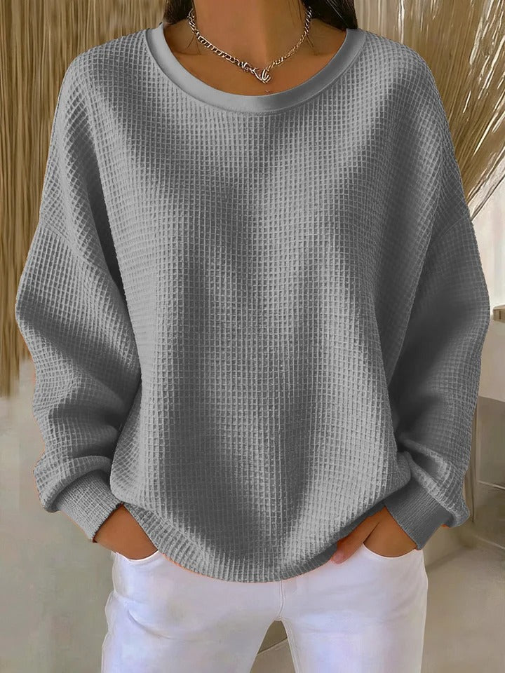 Relaxed fit women's cozy sweater, featuring a textured knit, round neck, long sleeves.