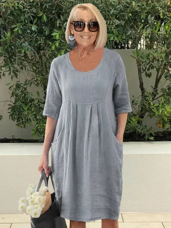 Loose women's midi dress with practical side pockets, a comfortable and stylish option for everyday summer outfits.