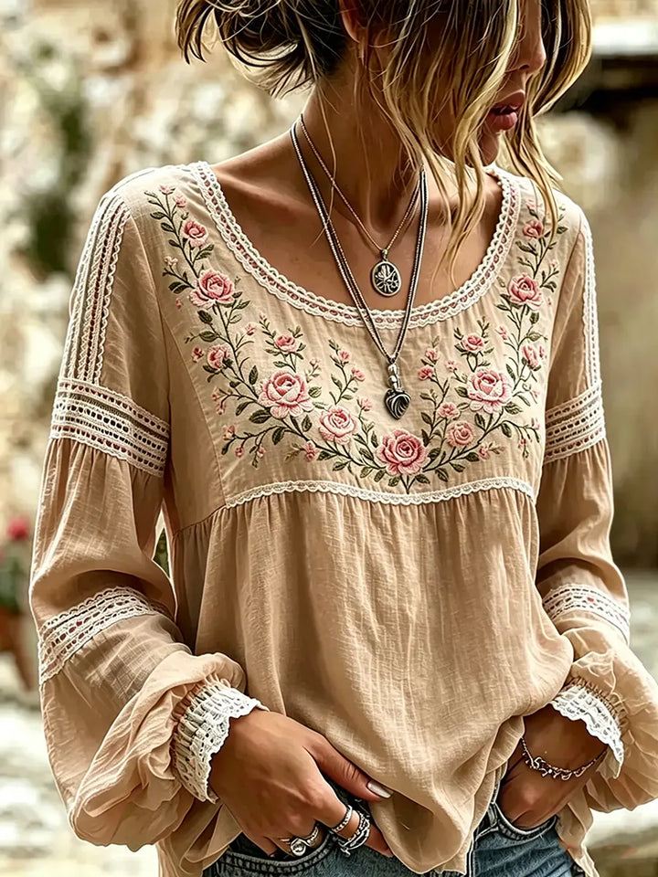 Close-up of beautiful embroidery on a women's long sleeve casual blouse top, showcasing fine detail.