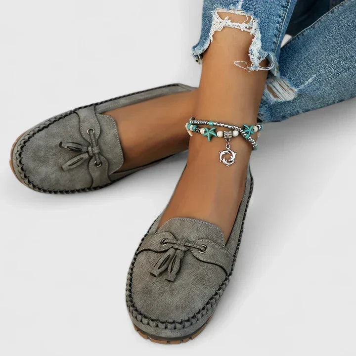 Chic women's slip-on loafers with delicate daisy bow detail. Comfortable flats for versatile everyday fashion.