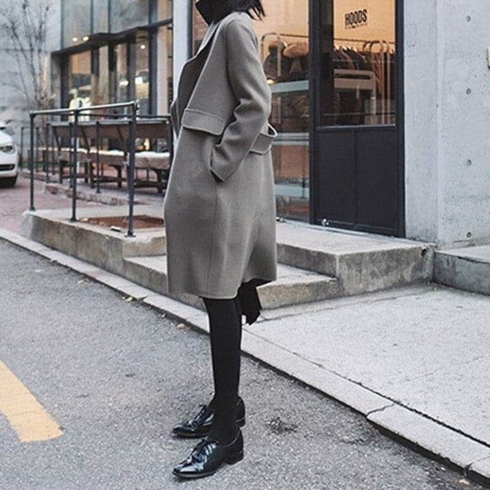 Elegant women's long winter coat for cold weather. Knee-length, providing stylish warmth and modern outerwear fashion.