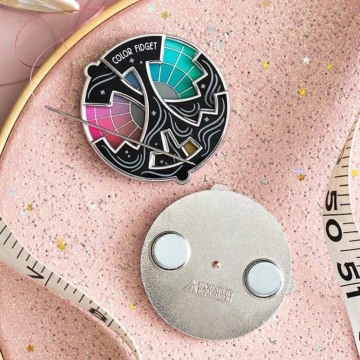 Enamel pin fidget toy with rotating color wheel, promoting focus & stress relief. Great for creative minds.