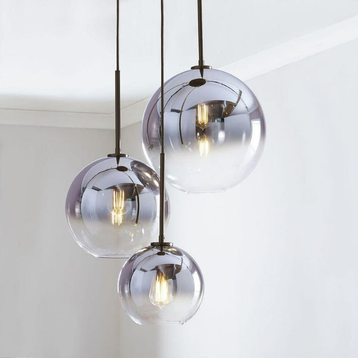 Modern glass ball pendant light with a subtle gold accent, enhancing elegant living spaces.