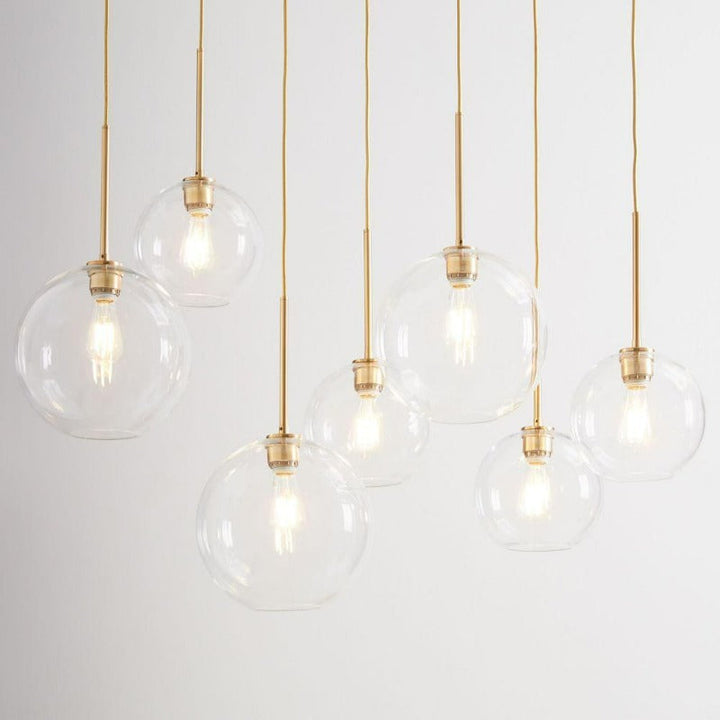 Spherical glass pendant light with brass detail, a luxurious contemporary indoor lighting choice.