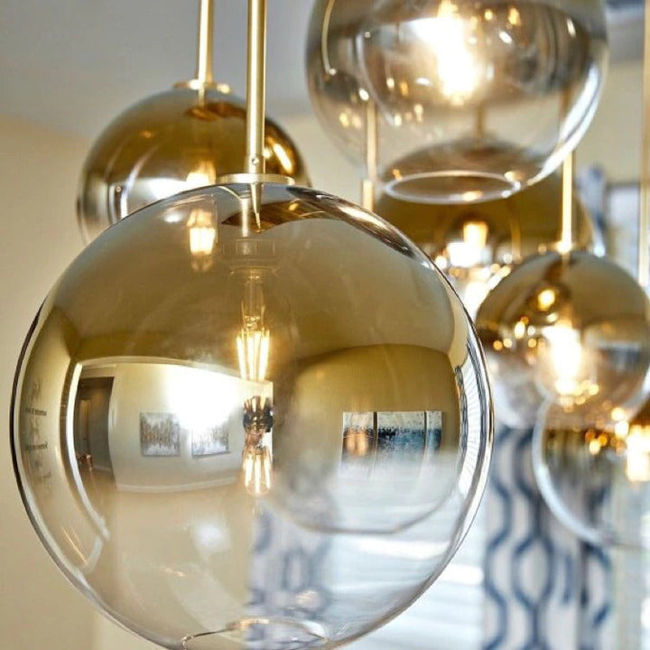 Contemporary glass ball pendant light with a delicate gold accent, great for modern spaces.