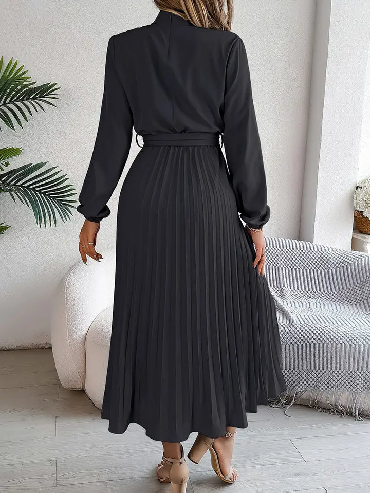 Close-up of a women's belted pleated midi formal dress, highlighting the elegant pleats and belt.