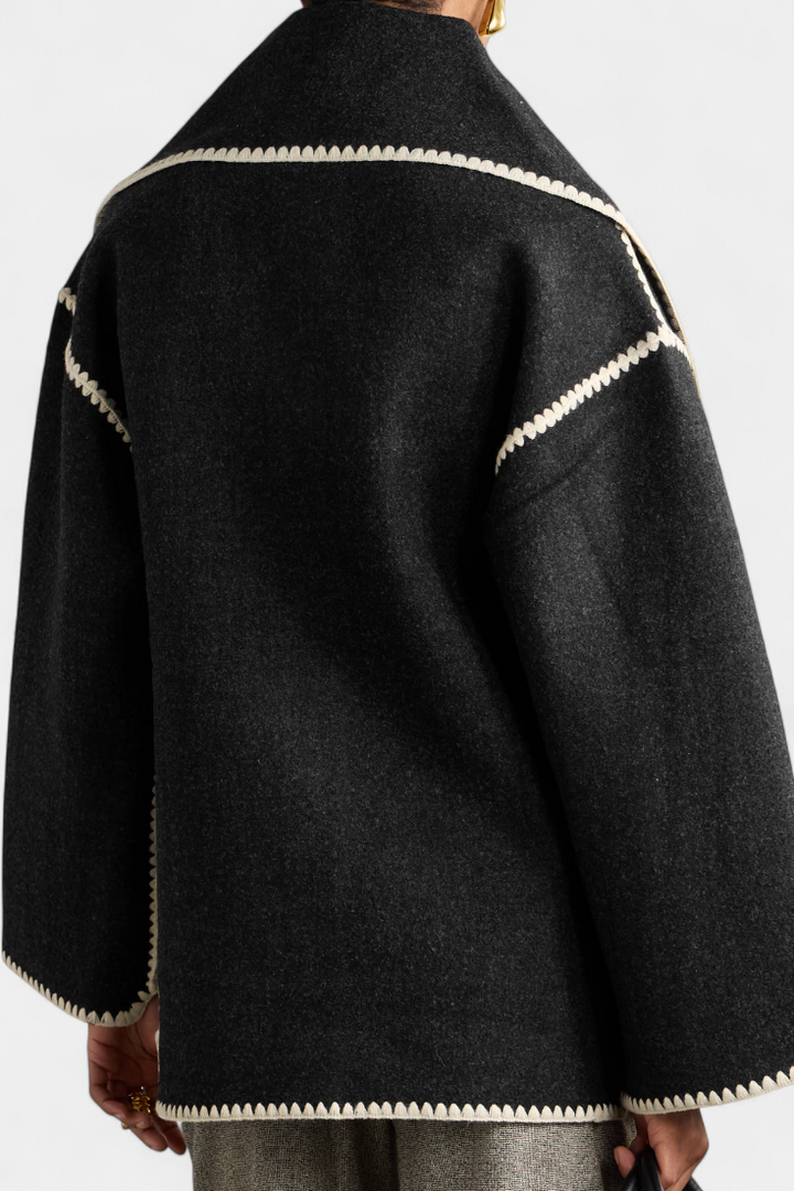 Women's elegant scarf coat with fringe trim, providing chic warmth as fall/winter outerwear.