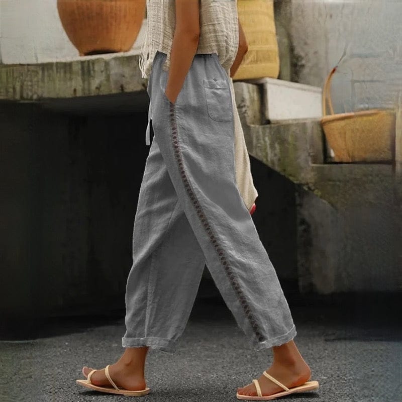 Comfortable women's cropped linen pants featuring a stylish elastic waist & eyelet trim, ideal for everyday or travel.