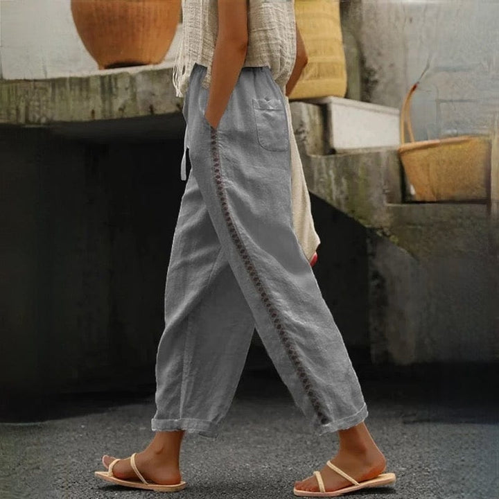 Comfortable women's cropped linen pants featuring a stylish elastic waist & eyelet trim, ideal for everyday or travel.