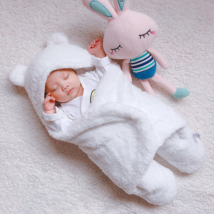 Cozy newborn swaddle blanket with legs & hood. Soft sherpa fleece sleep sack for comfortable baby sleep.