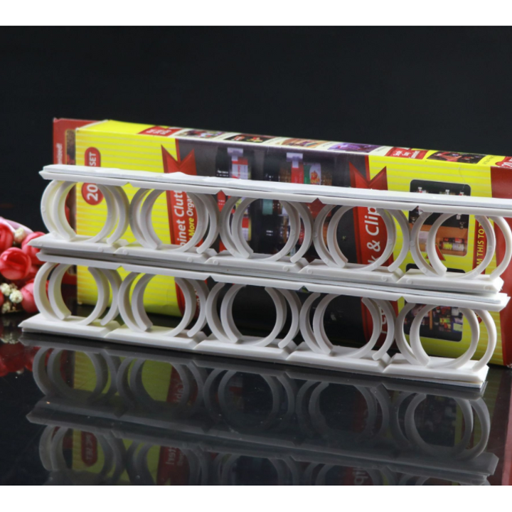 Close-up of a clear adhesive spice organizer strip, securely holding round spice jars in a cabinet.