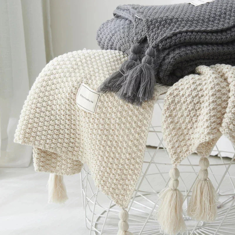 Modern knitted wool throw blanket with tassels, perfect for a contemporary Scandinavian home.