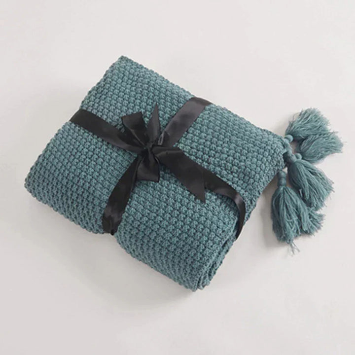 Knitted wool throw blanket with tassels, soft and warm for ultimate comfort.