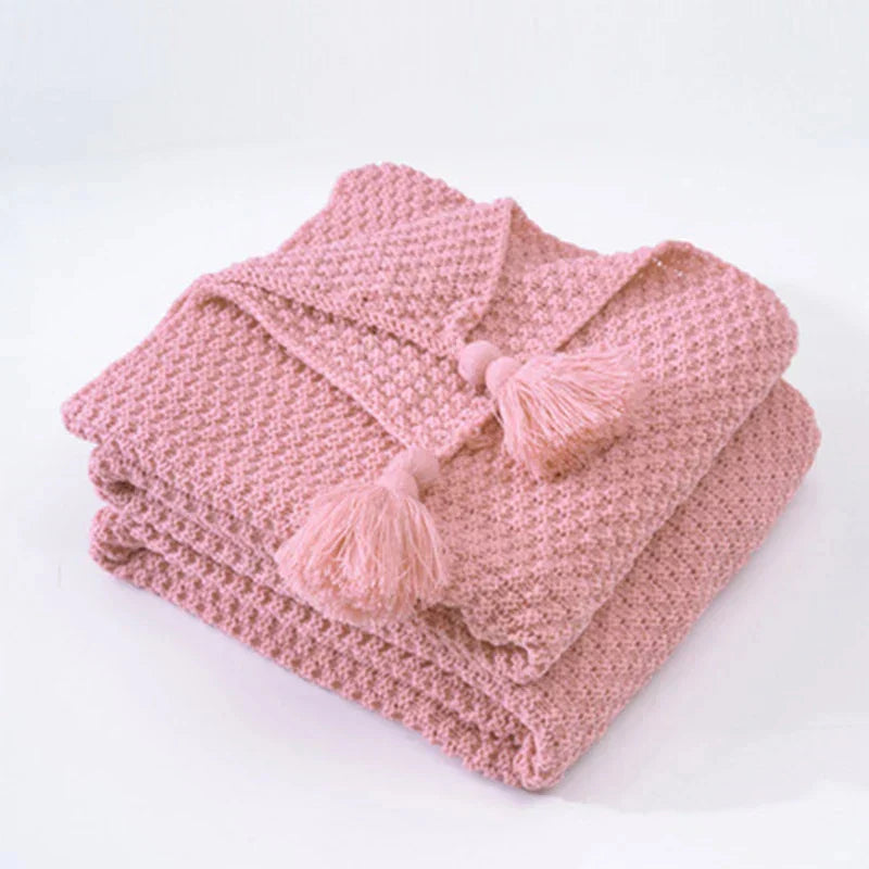 Scandinavian-style knitted wool throw with tassels, ideal for modern home decor.