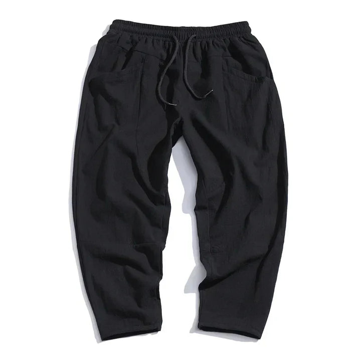 Modern men's casual cropped pants featuring a drawstring waist and relaxed fit, perfect for comfortable wear.