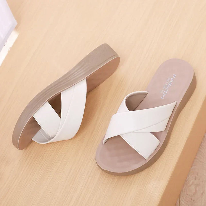 Beige open-toe wedge slippers for women. Stylish and comfortable summer footwear with a casual wedge heel.