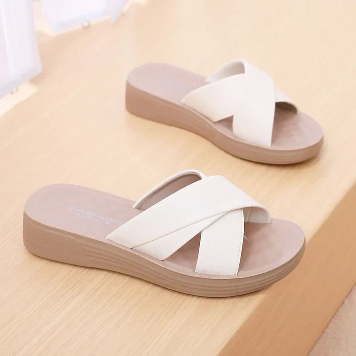 Black open-toe wedge slippers, ideal for ladies' casual or everyday summer style. Comfortable and chic.