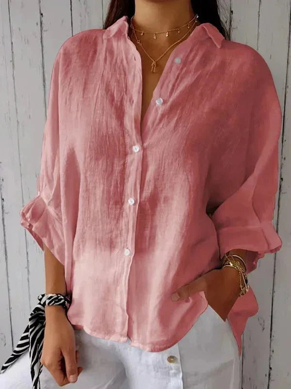 Pink women's oversized linen shirt with a relaxed fit and trendy rolled cuffs, a comfortable long-sleeve button-down.