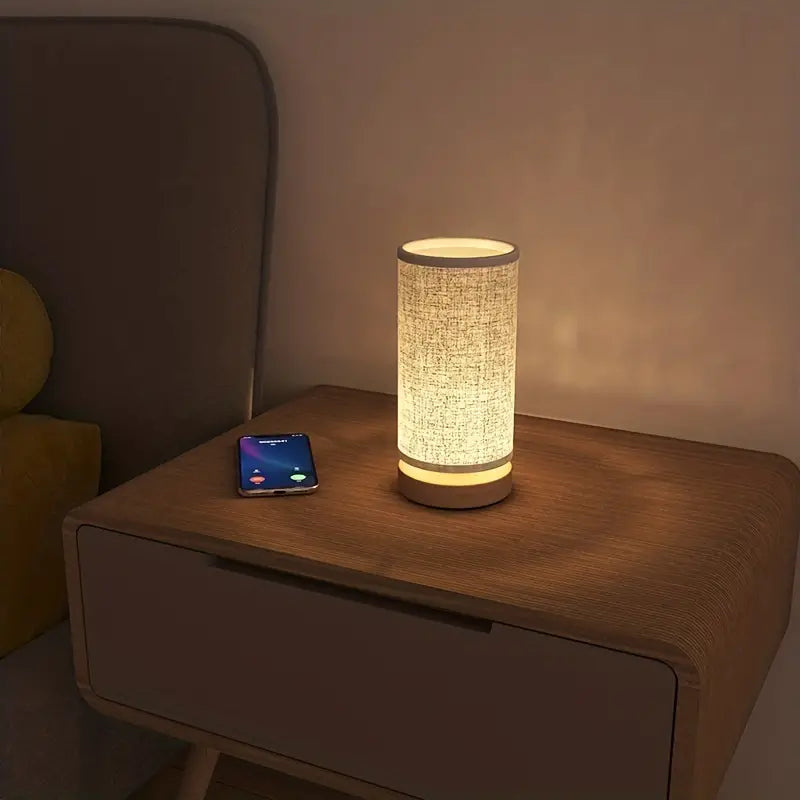 Decorative linen look table lamp. Elegant modern design, ideal as a bedside light for cozy bedroom ambiance.