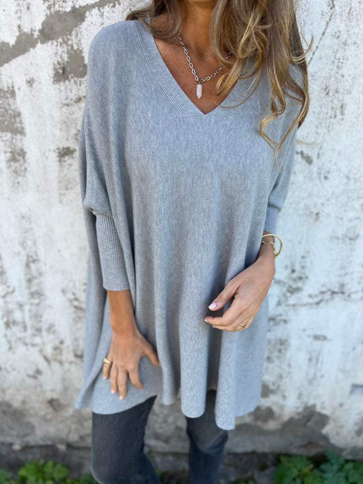Stylish women's oversized V-neck long sleeve top, great for versatile casual wear.