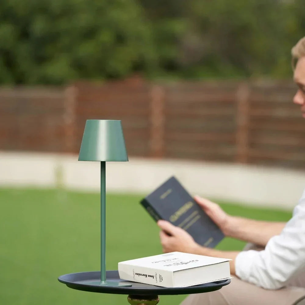 Sleek modern LED table lamp, dimmable, rechargeable. Enhances indoor/outdoor living spaces.