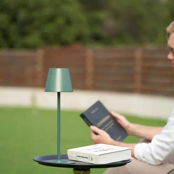 Sleek modern LED table lamp, dimmable, rechargeable. Enhances indoor/outdoor living spaces.