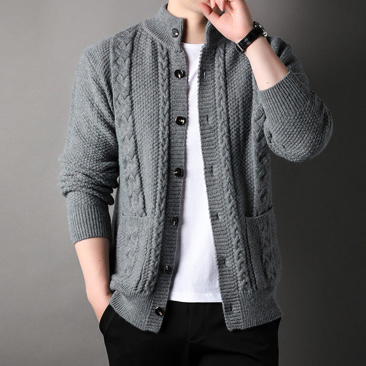 Detailed men's cable knit cardigan featuring a stand collar & button front. Essential fall knitwear.