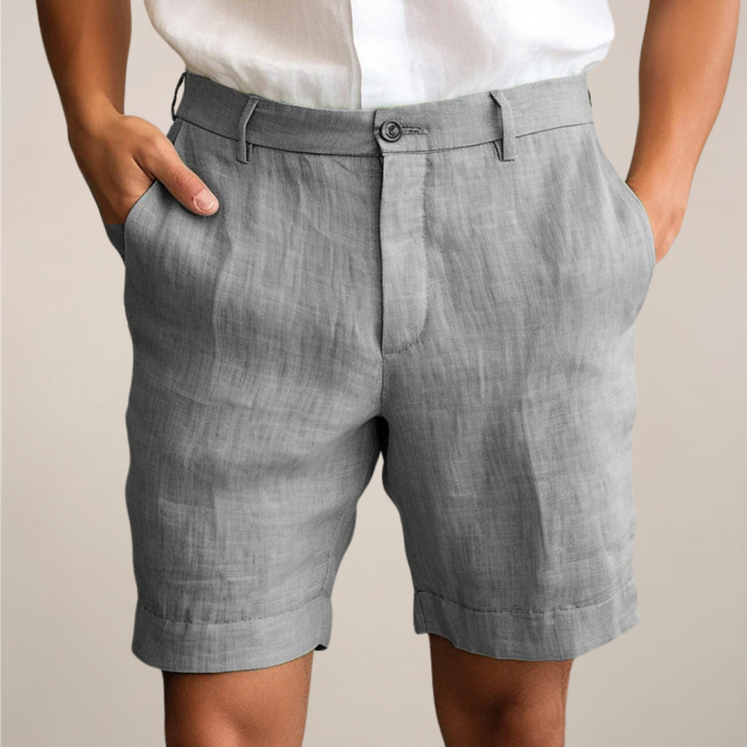 Man wearing comfortable men's summer beach shorts with elastic waist, walking on a sunny beach.