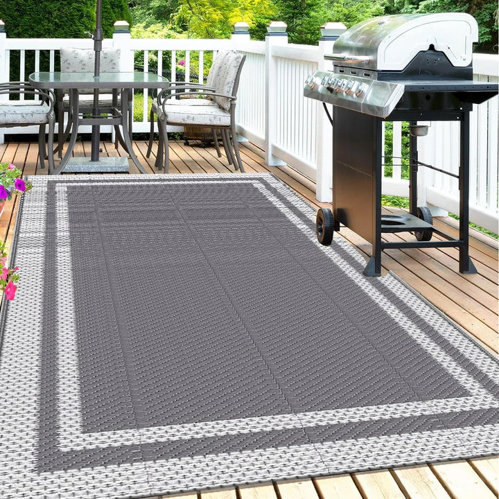 Modern grey white geometric outdoor mat for patio & deck. Reversible, easy-clean floor covering for outdoor living spaces.