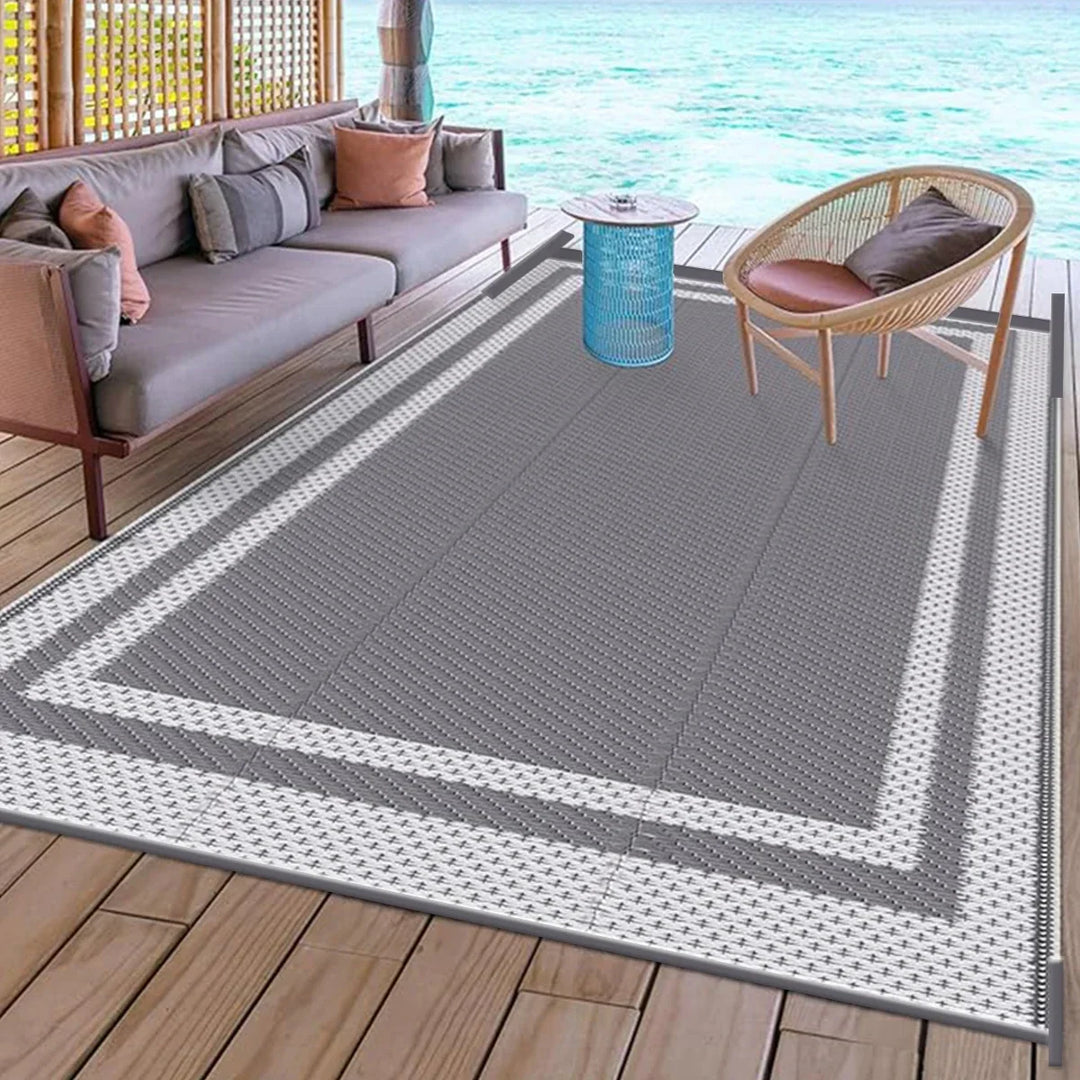 Grey white modern geometric outdoor area mat. Durable and reversible for patio, deck, or camping. Stylish outdoor living floor covering.