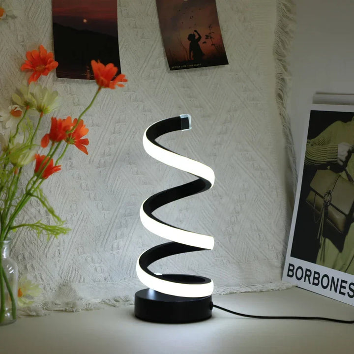Contemporary black S-shaped task lamp for minimalist home office. Provides bright, eye-caring LED work light.