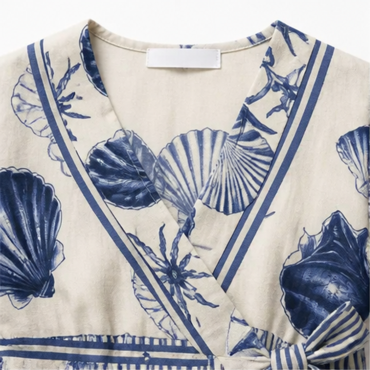 Comfortable women's casual wrap romper featuring a beautiful coastal shell print. Perfect for vacation.