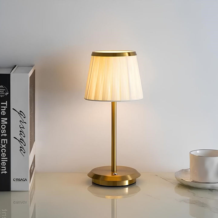 Unisex gold table lamp with fabric shade & modern aesthetic. A stylish rechargeable & dimmable LED light for decor.