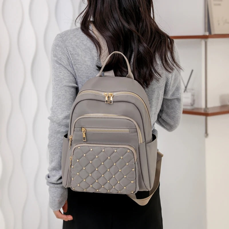 Women's water-resistant nylon backpack in black, a lightweight and practical choice for travel & school.