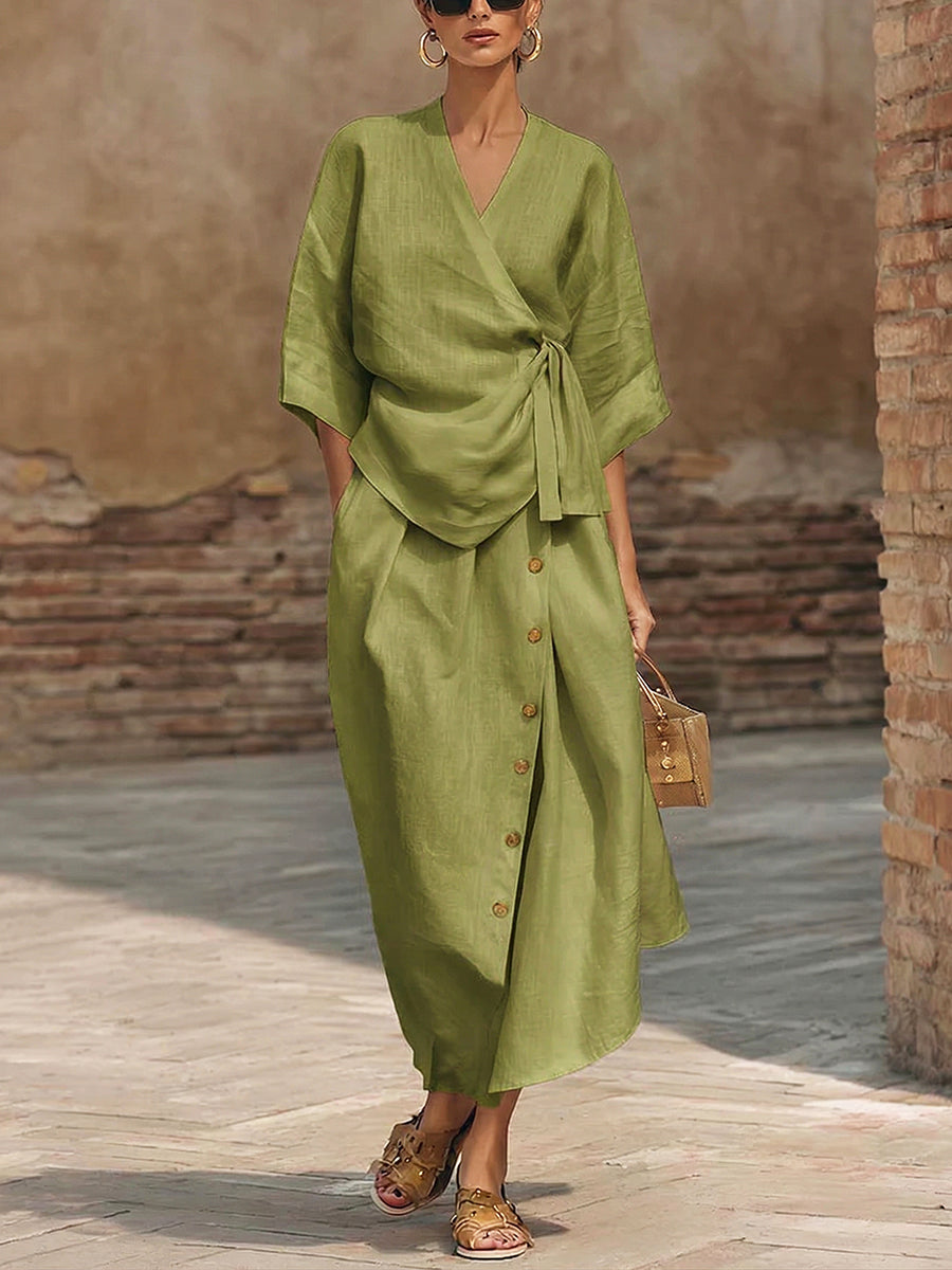 Sophisticated women's outfit set showcasing a fashionable wrap top and a classic buttoned midi skirt. Versatile look.