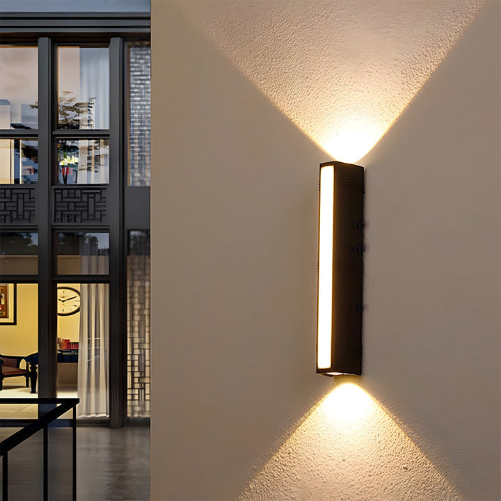 Sleek modern minimalist black LED tube wall light, perfect for outdoor patios or indoor accent lighting.