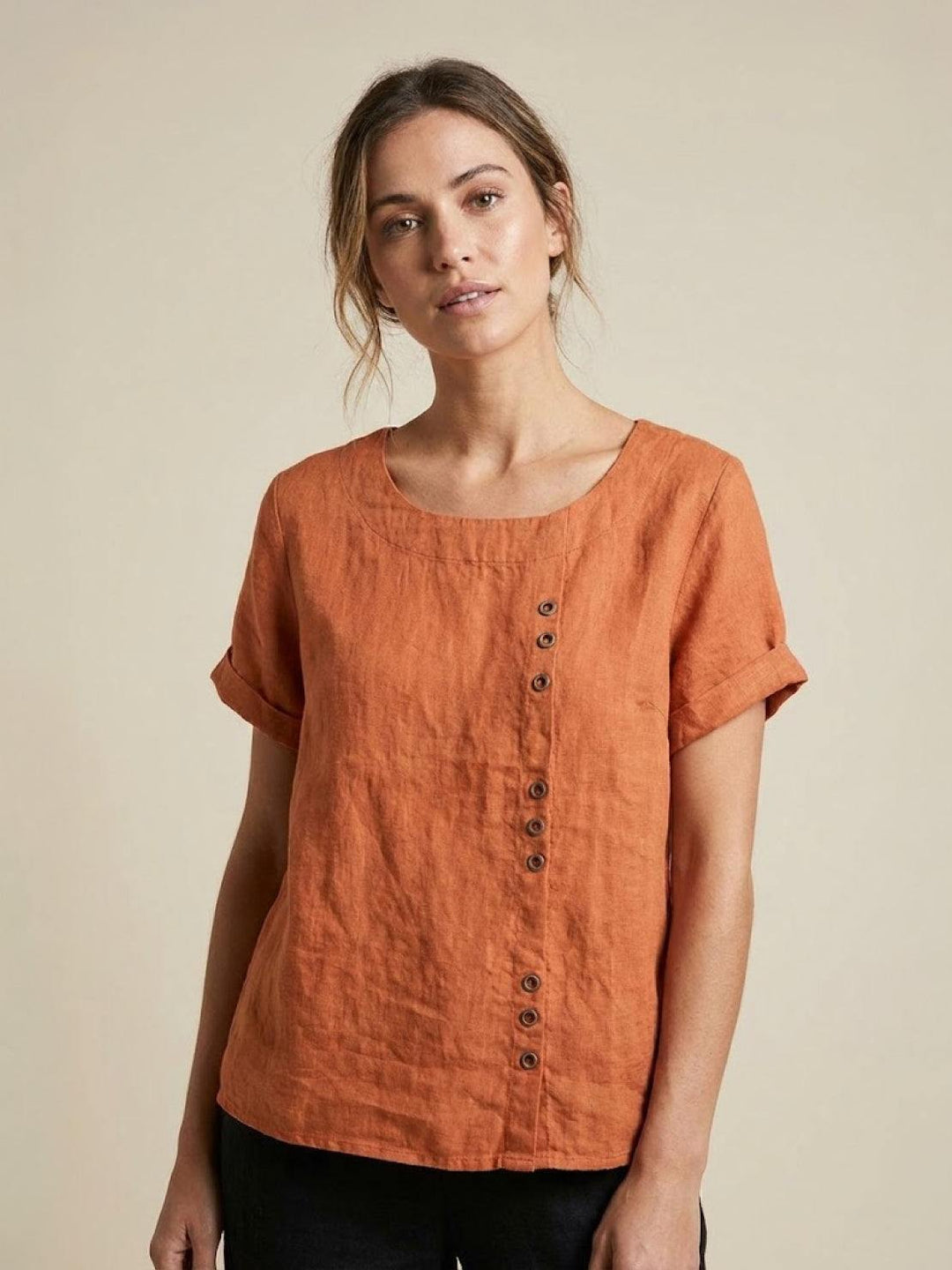 Womens apparel: Casual short sleeve top with scoop neck, button details, and relaxed fit.