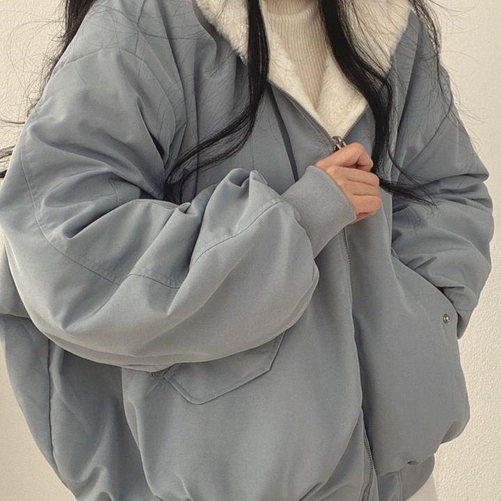 Cozy women's reversible winter jacket, hooded for extra warmth against cold weather.