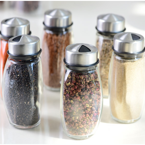 Space-saving rotating spice rack with 6 glass jars for efficient kitchen storage of cooking spices and seasonings.
