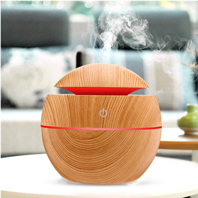 Mini wood grain diffuser emitting a fine mist, diffusing essential oils for peaceful relaxation.