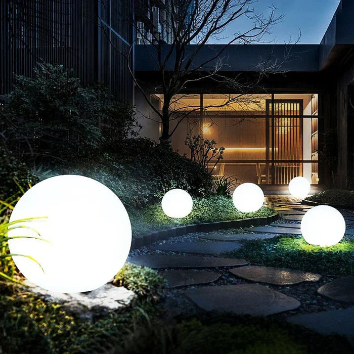 Wireless GlowSphere garden lamp creating warm mood lighting on a deck.