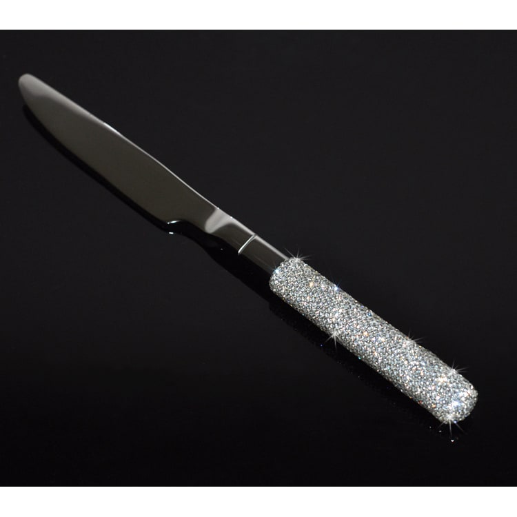 Detailed view of elegant gold & silver forks, knives, spoons from a 20-pc flatware set with rhinestone handles.